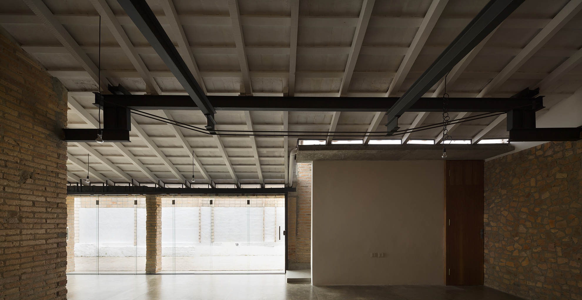Interior view of Oficina Nordeste Curuguaty, highlighting reuse of local resources and sustainable construction methods.