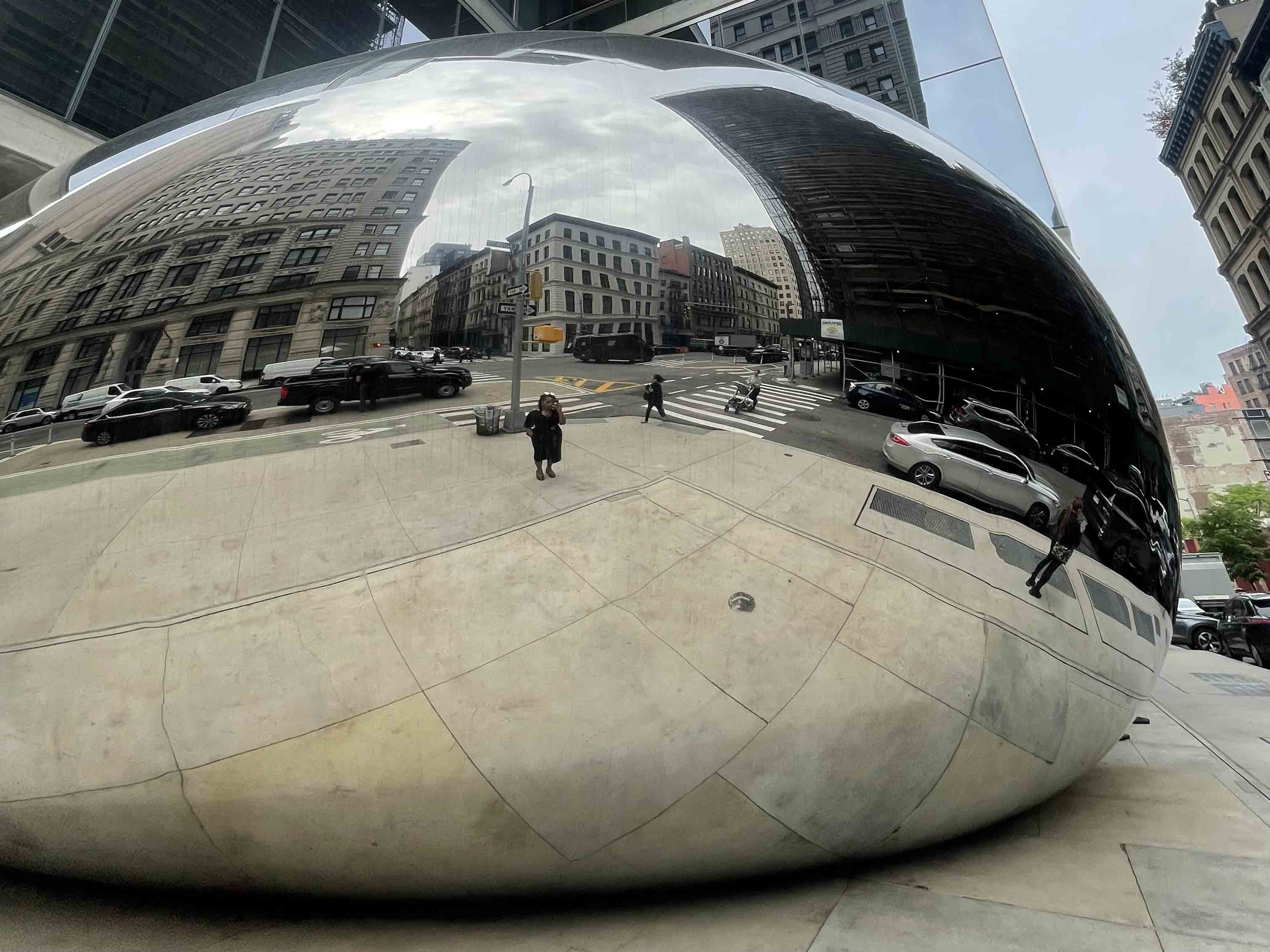 Reflective urban sculpture interacting with its surroundings as part of the architectural design of the cityscape.