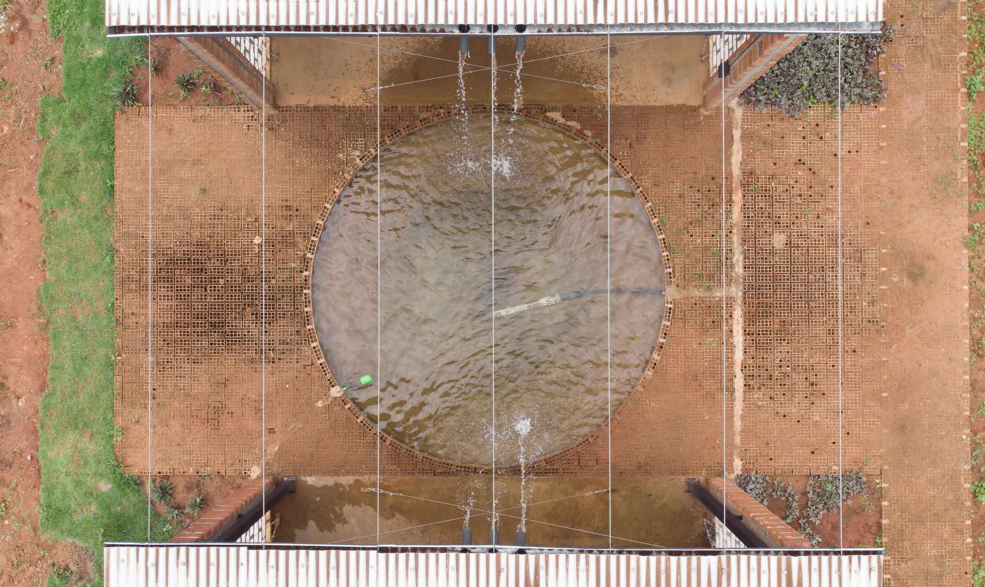 Aerial view of central pool at Oficina Nordeste Curuguaty, created with reuse of local bricks for passive cooling.