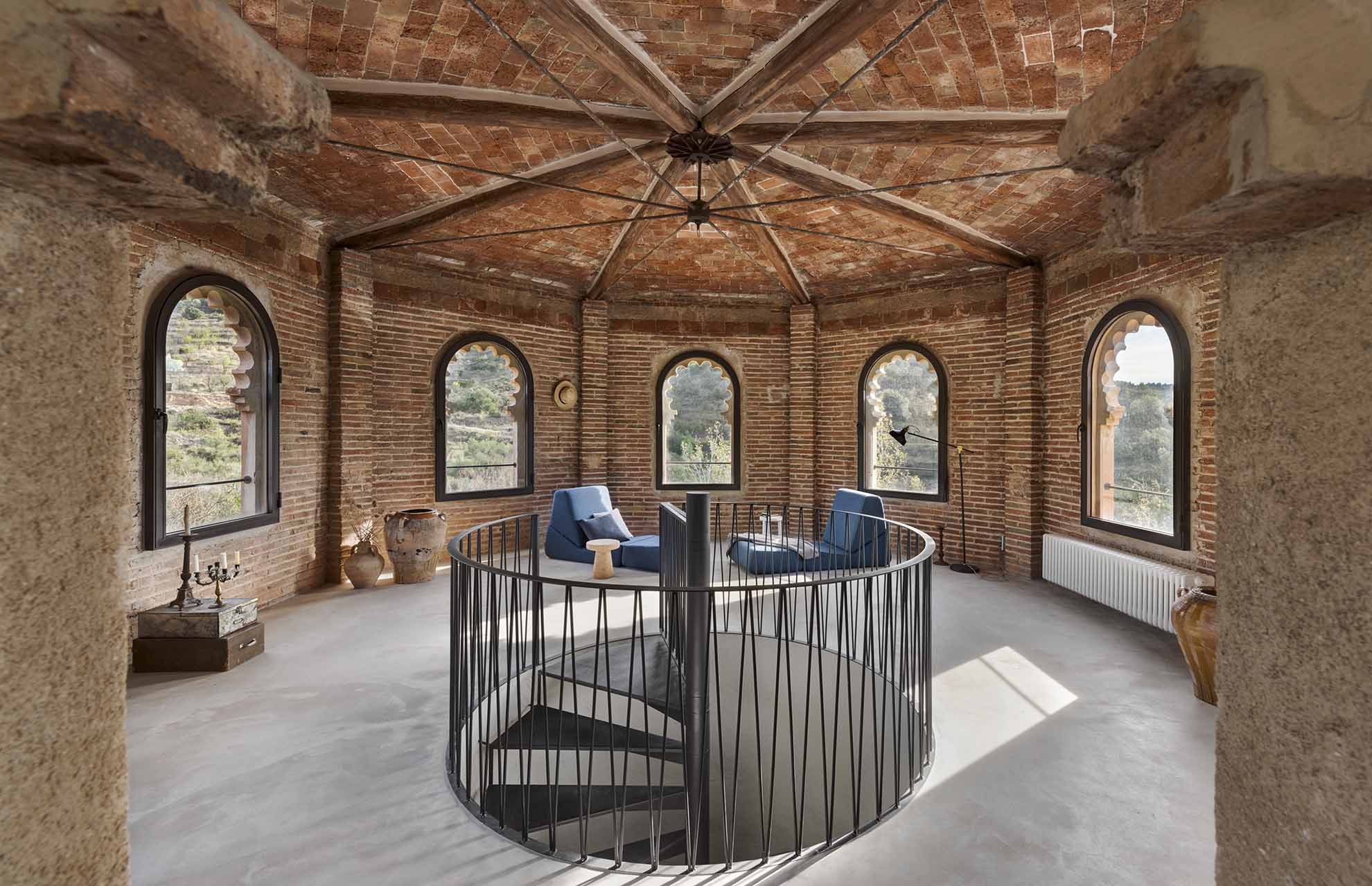 Restored circular tower interior with vaulted brick ceiling and stone columns, showcasing historic building materials and craftsmanship.