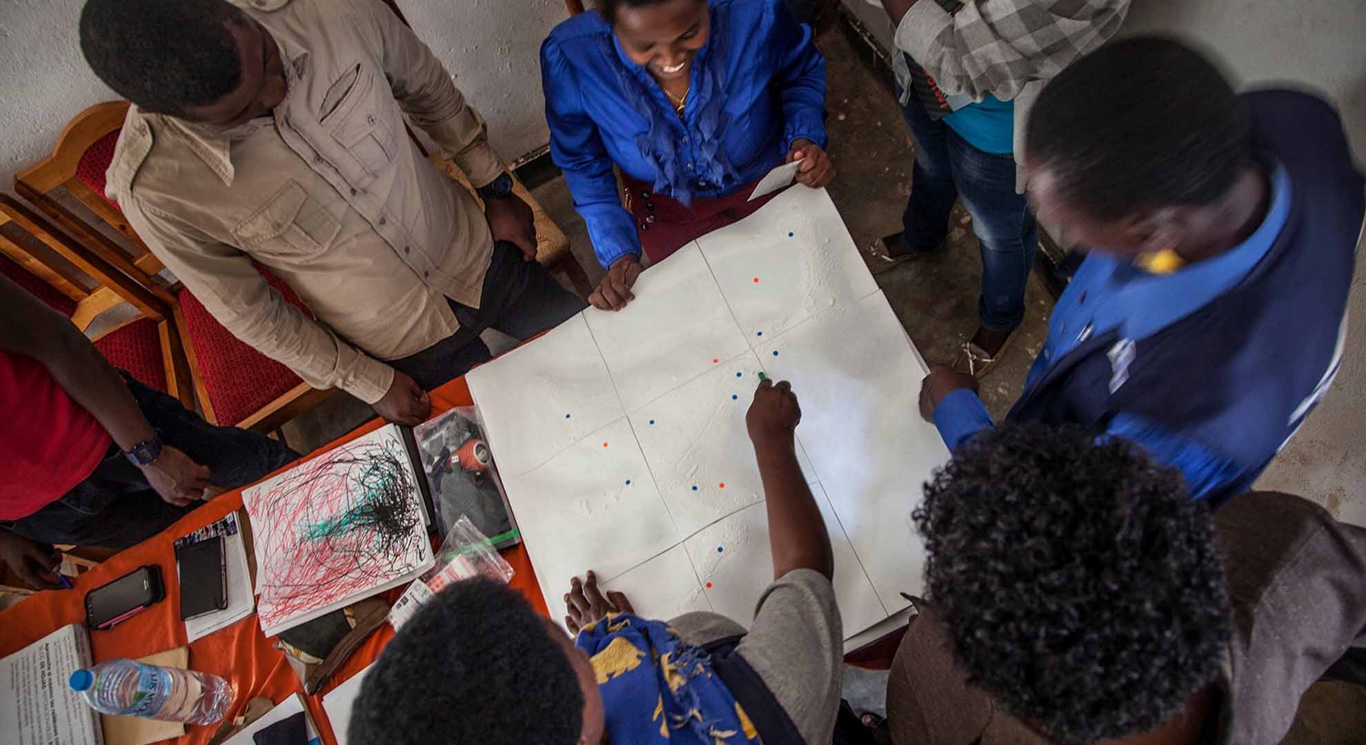 A participatory design session of neighbourhood improvements at Kiziba refugee camp, Rwanda, in September 2017, using a 3D printed model developed with satellite imagery and the software Maya. Photo © Joan Amorós Elorduy